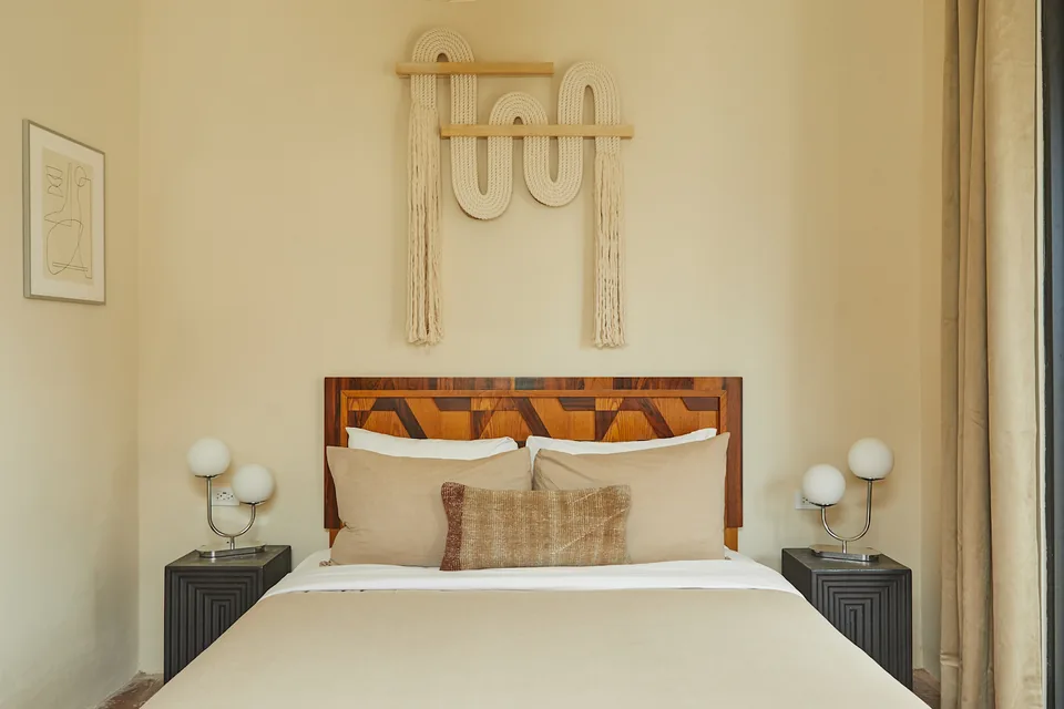 Queen bed with woven wall hanging in APT 1