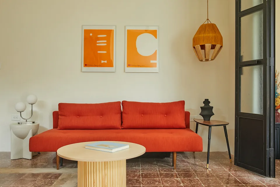 Red sofa and woven pendant in the APT 1 living room