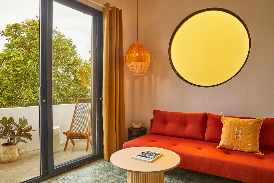 Circular amber window and red sofa in APT 5