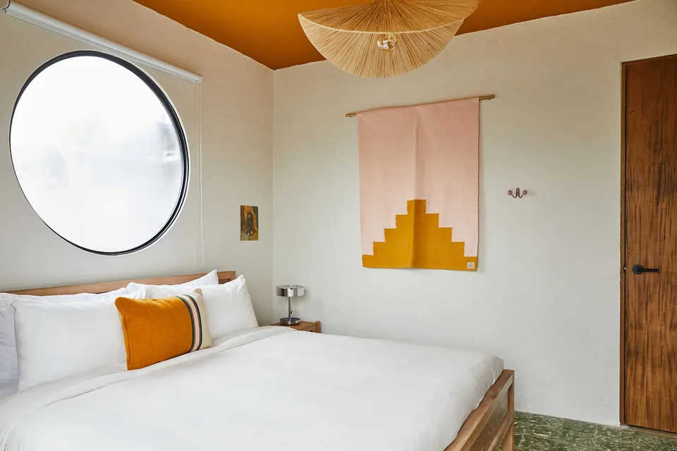 Bright bedroom with wooden bed frame in APT 8