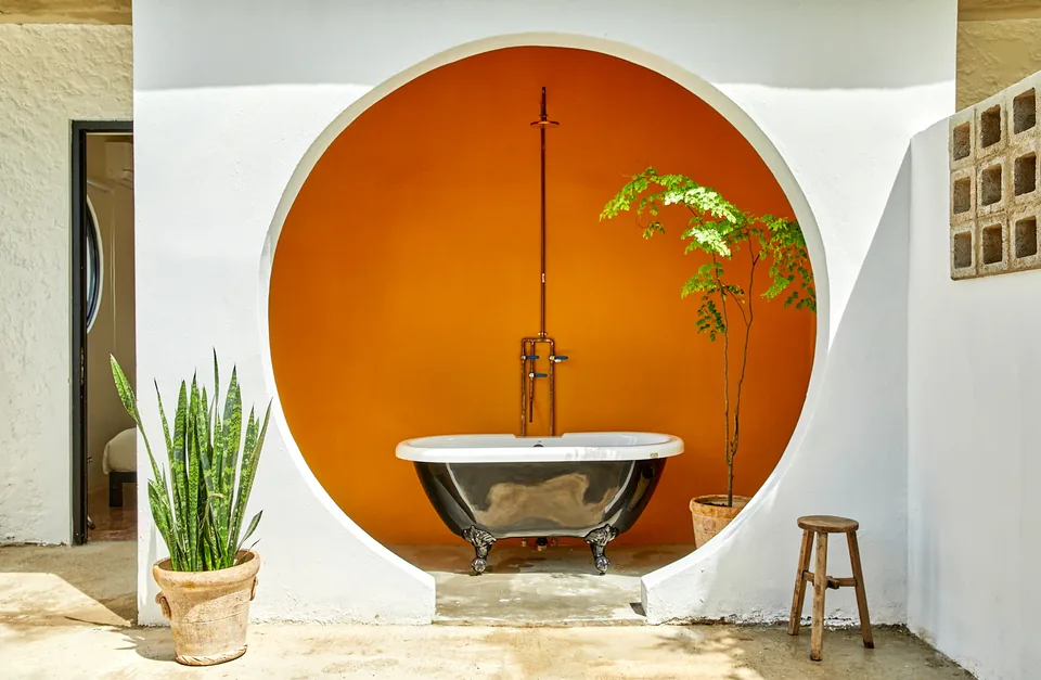 Outdoor bath framed by an orange circular alcove at APT 2