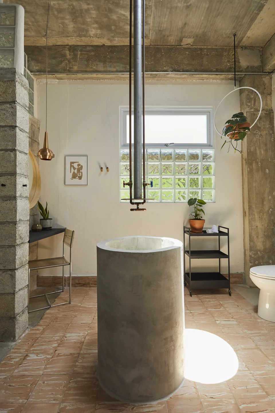 A sculptural basin and designer shower in DA1’s concrete bathroom