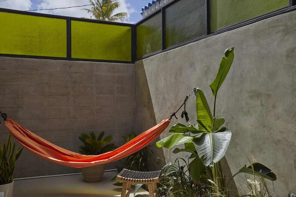 An orange hammock, tropical planting and concrete walls on DA1’s terrace