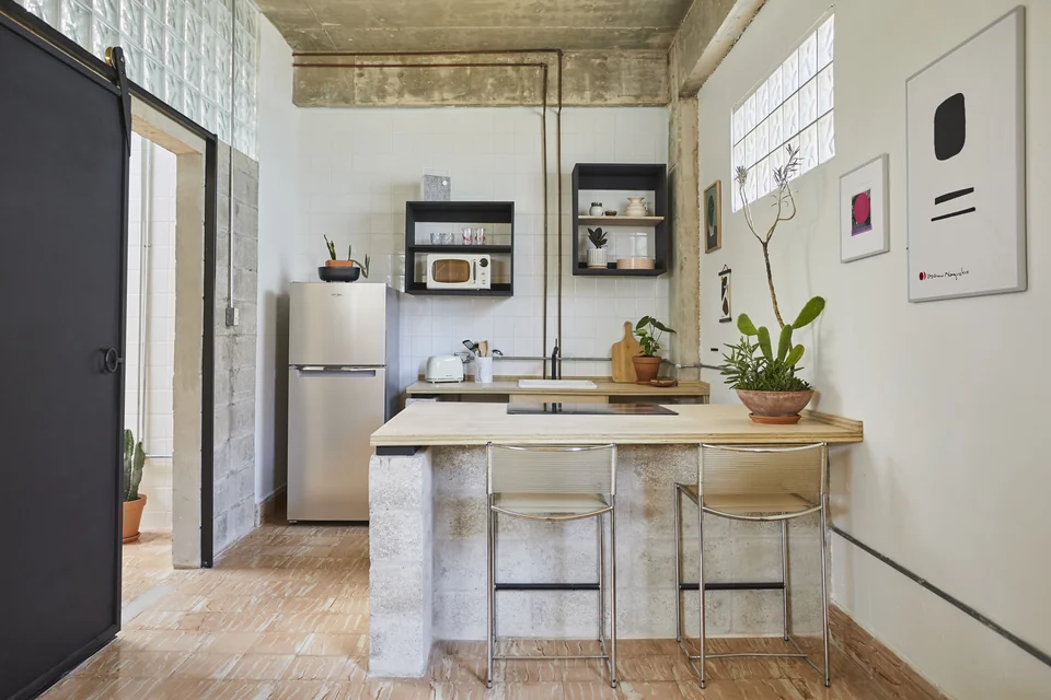 DA1’s full kitchen, eat-in counter and exposed concrete walls