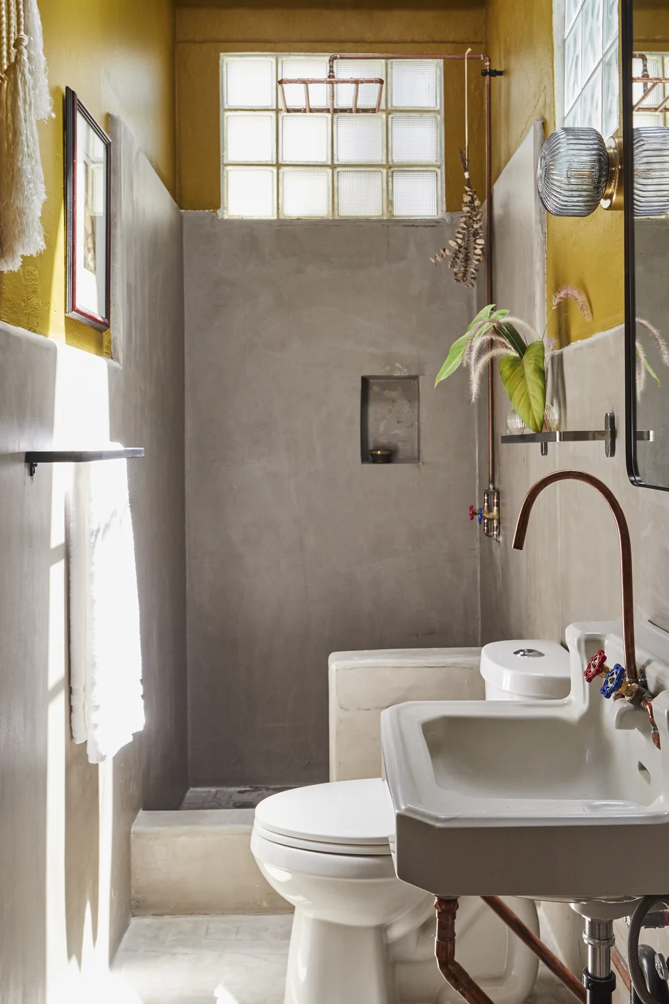 DA2’s concrete bathroom and yellow walls beside the shower