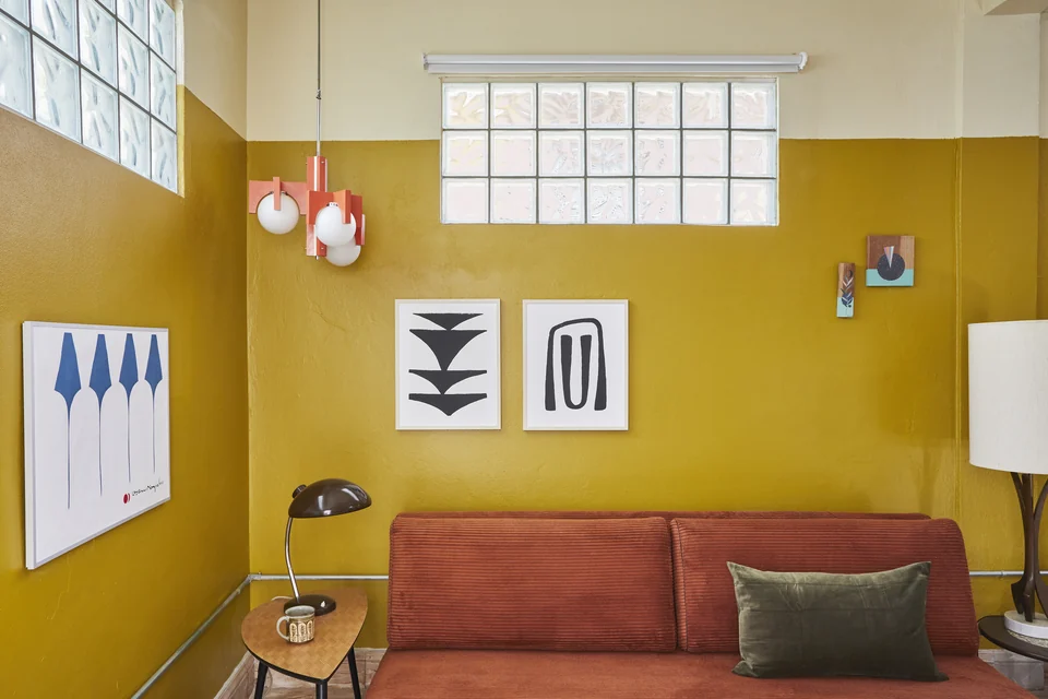 DA2’s terracotta sofa bed and bright yellow living-room walls