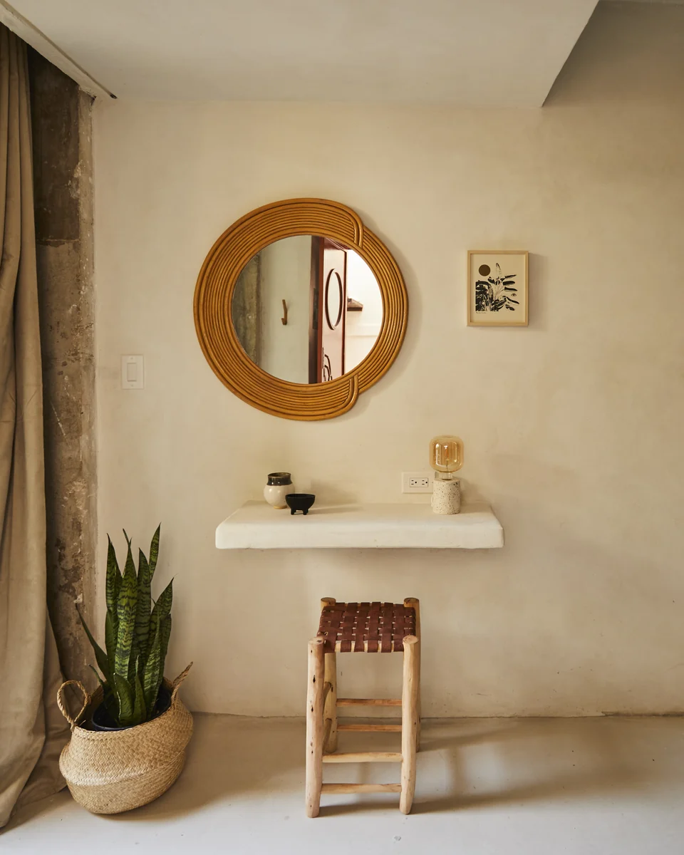 A round mirror, concrete writing desk and small chair in JA1