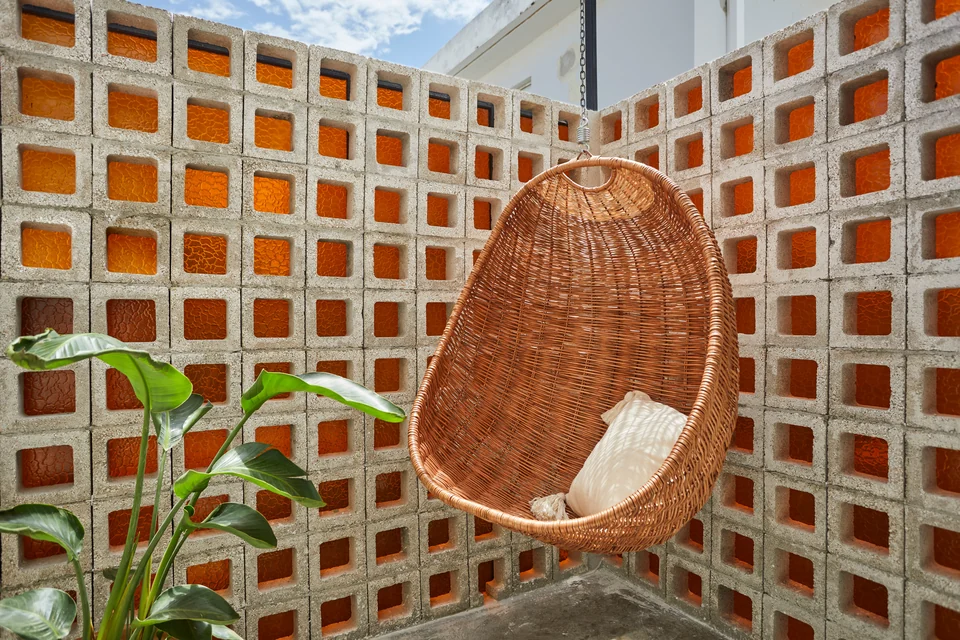 A woven hanging chair against terracotta breeze blocks on JA2’s terrace