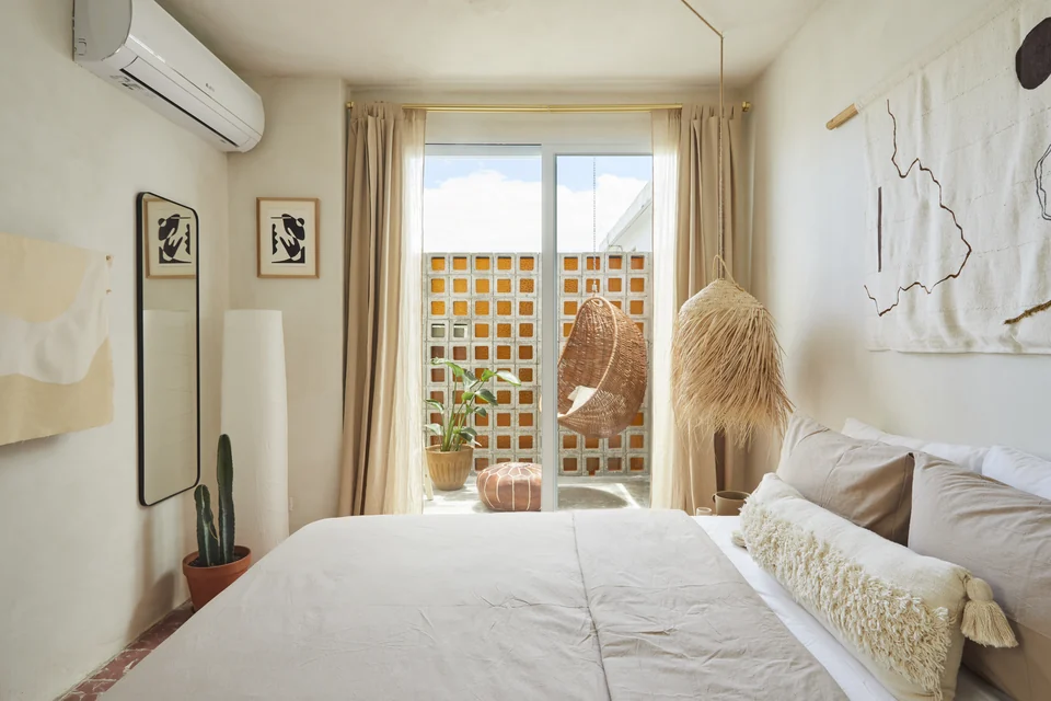 JA2’s queen bed and sitting area opening toward a planted terrace