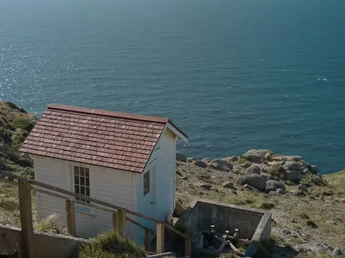 image of small house next to the ocean.