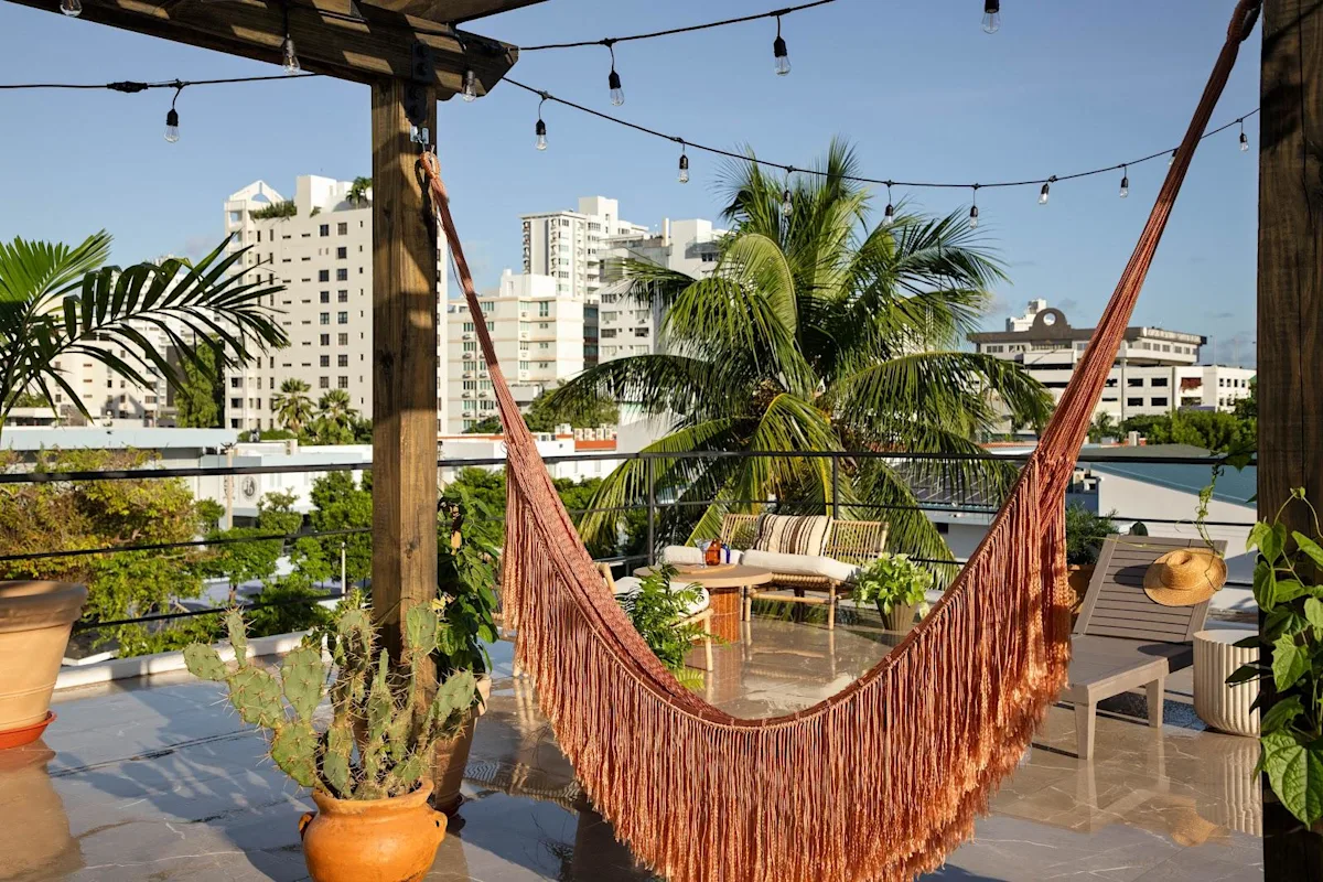 The rooftop terrace and hammock at Maru by DW in Condado, with the neighbourhood's towers behind.