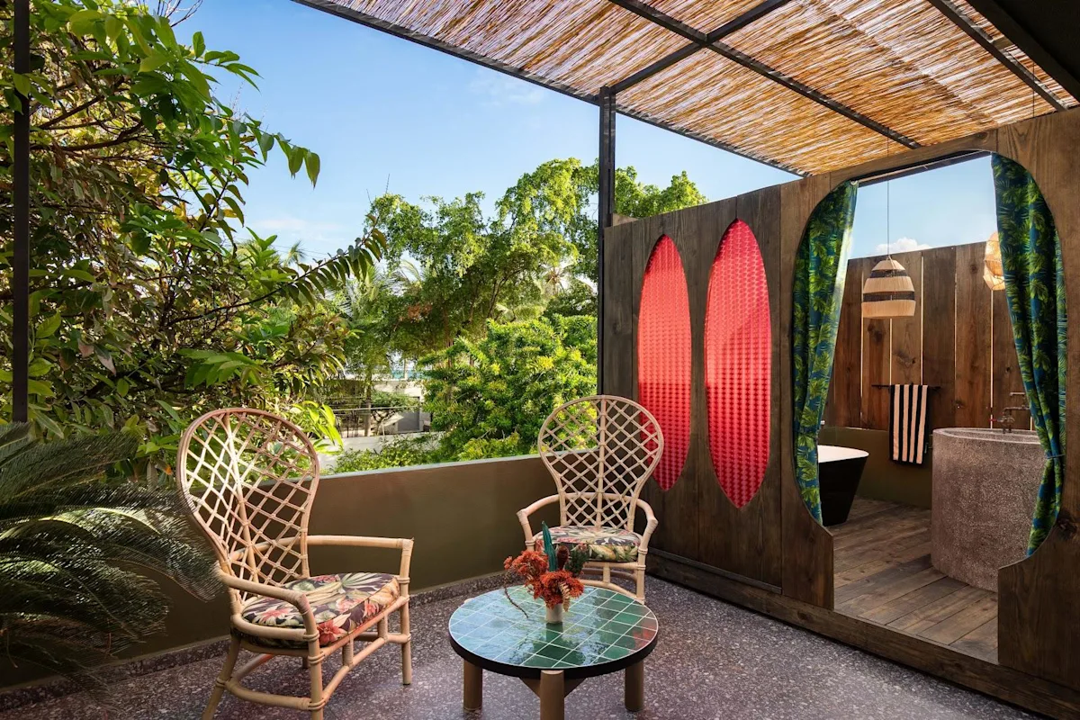 A private terrace with rattan chairs at Dreamcatcher, the flagship boutique hotel of Dreamers Welcome, looking over Ocean Park's palms.
