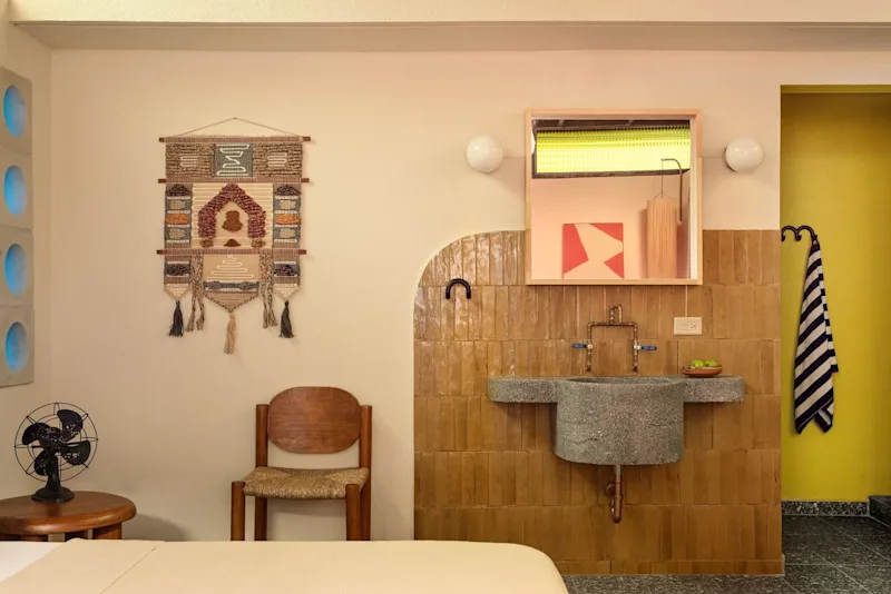 The Aya Suite at Dreamcatcher, the flagship boutique hotel of Dreamers Welcome in Ocean Park, San Juan, with its wooden vanity and arched wall.