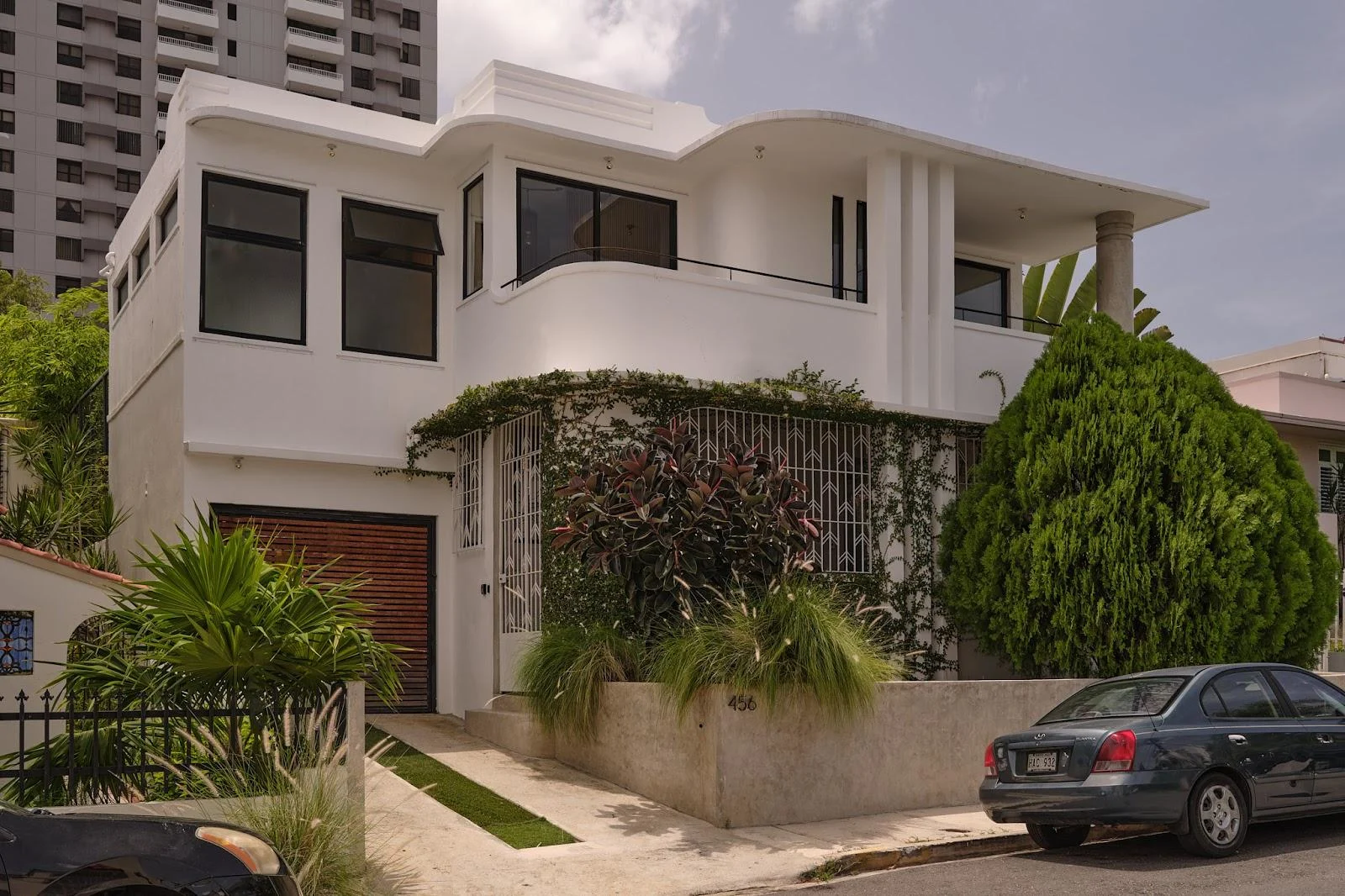 The white 1930s streamline moderne facade of Casa Frida by DW, a Dreamers Welcome vacation house in San Juan.