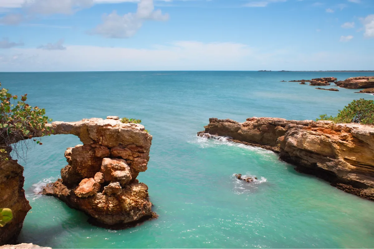 Rocky ocean cove with turquoise water and natural stone arch on the Puerto Rico coast.