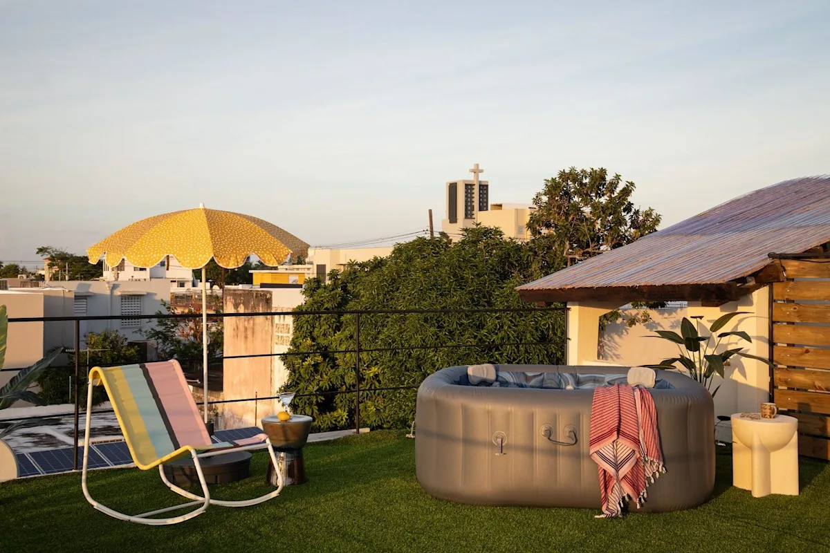 The rooftop deck and hot tub at Noa by DW, a Dreamers Welcome apartment stay in San Juan, at dusk.