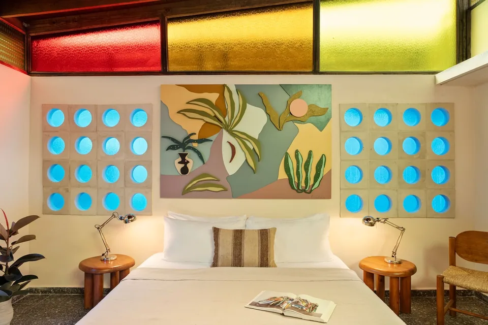 King bed, colored glass and artwork in the Aya Suite