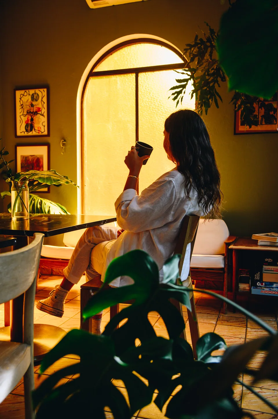 A guest having coffee in a sunlit Dreamcatcher dining space