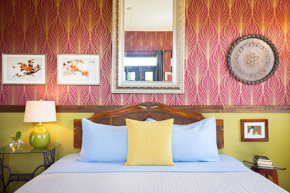 King bed and colorful botanical wallpaper in the Dreamcatcher Suite