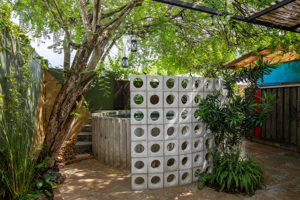 Tree-shaded Dreamcatcher pool courtyard enclosed by circular breeze blocks