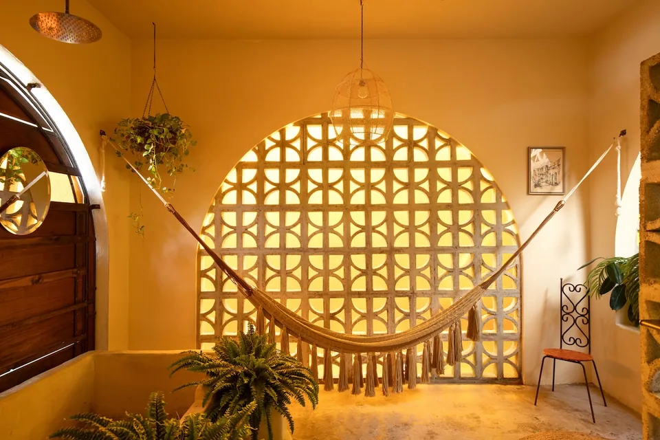 Amber light through a circular breeze-block window in the Romantic Suite bathroom