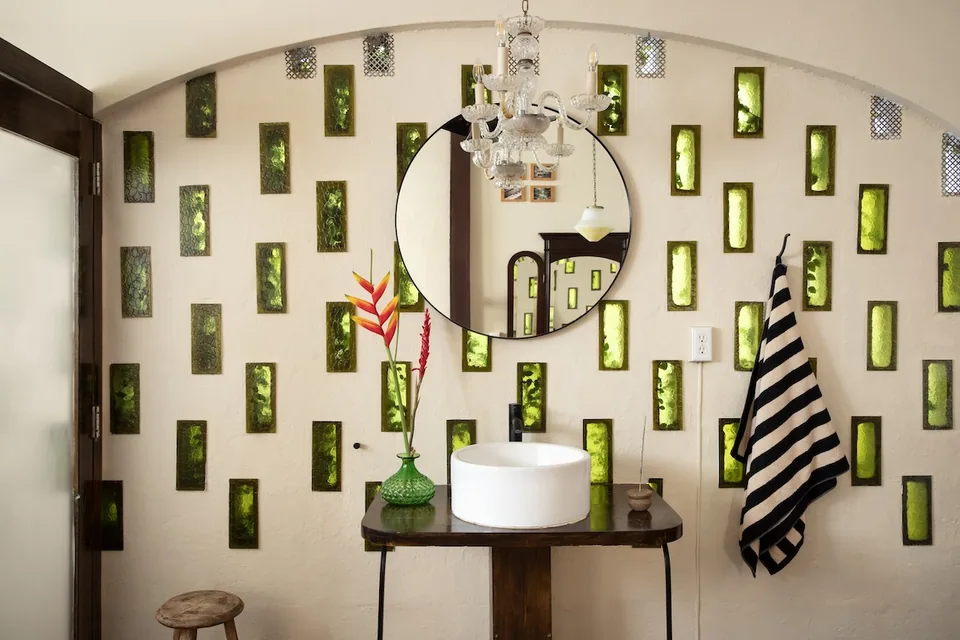 Private bathroom with green glass openings in the Traveler Room