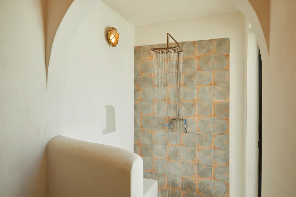 Arched shower opening and soft neutral walls in Nomad’s bathroom