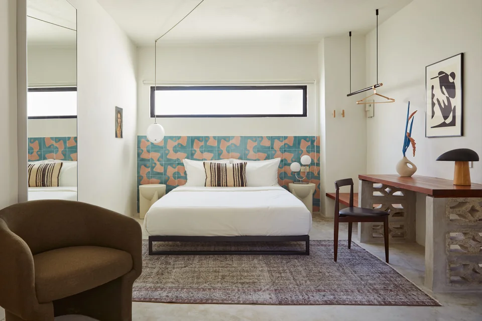 Queen bed, teal-and-coral tiles and a work desk in Nomad