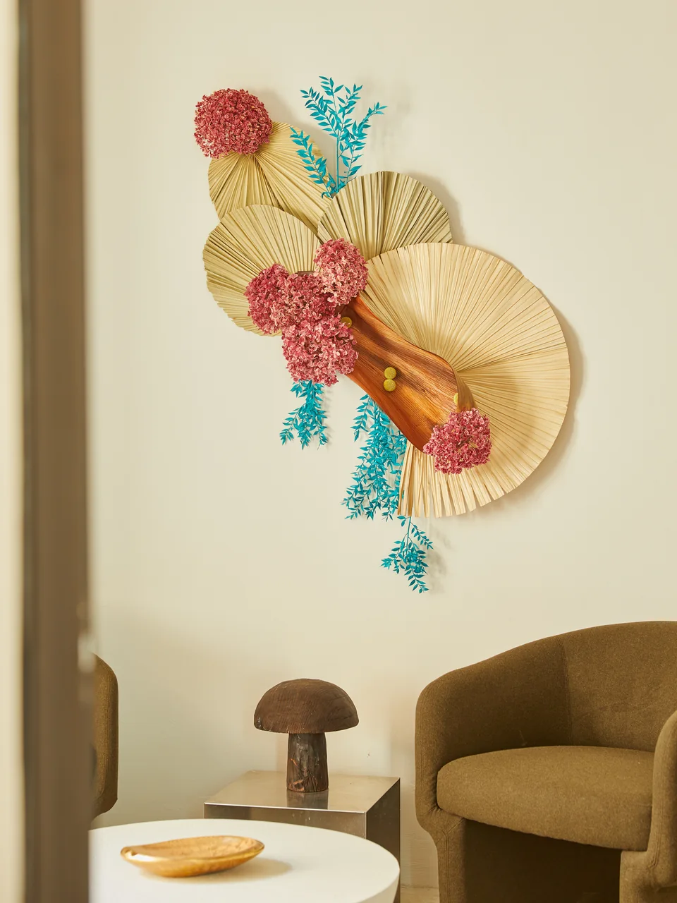 Colorful dried floral installation and a curved chair in Nomad