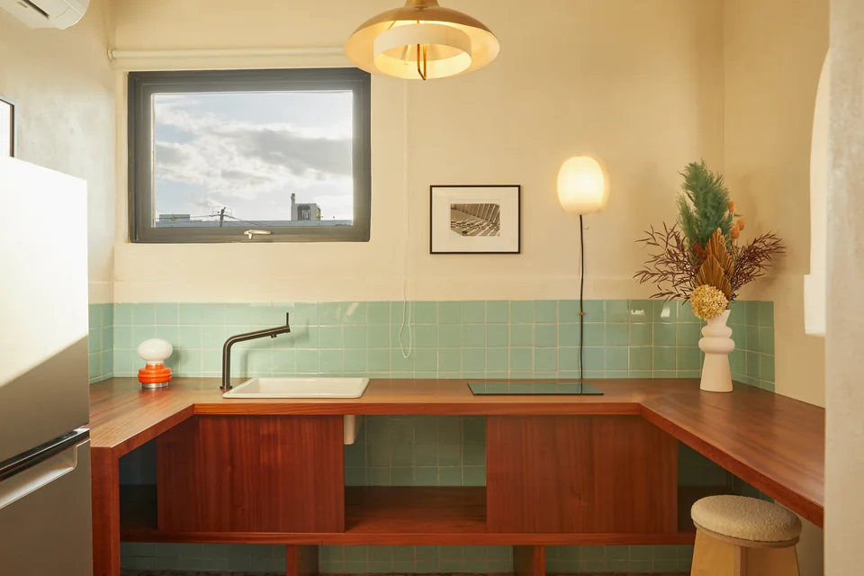 Full kitchen with turquoise tiles and wooden cabinetry in Poet