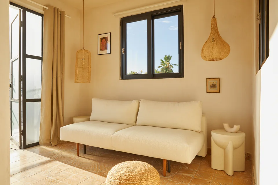 Sofa bed and warm white walls in Poet’s living room