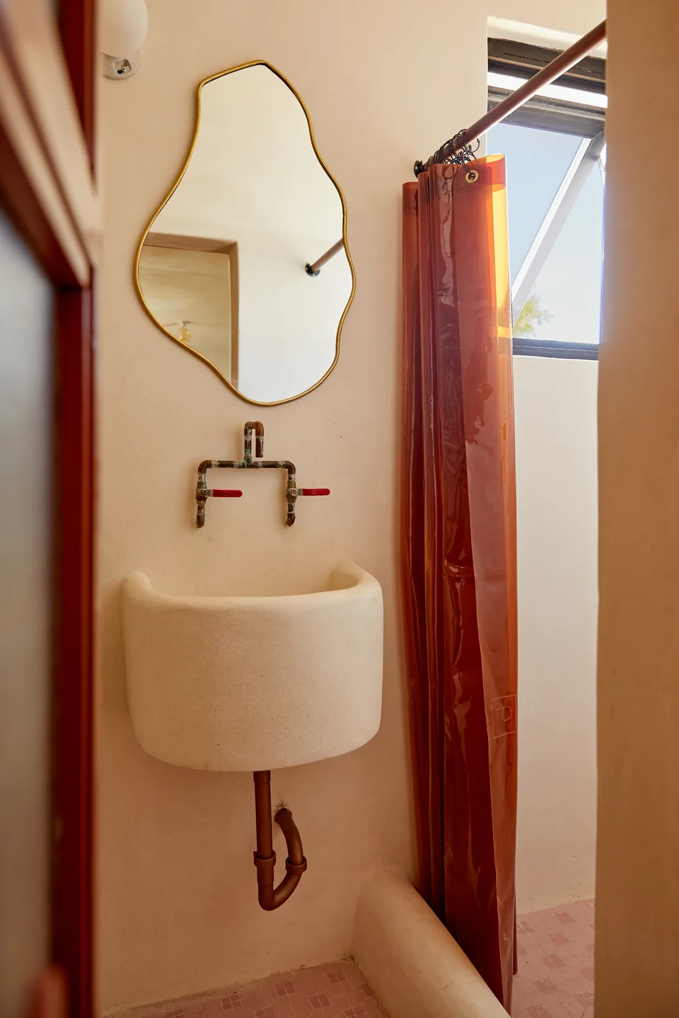 Sculptural mirror and custom sink in Romantic’s designer bathroom