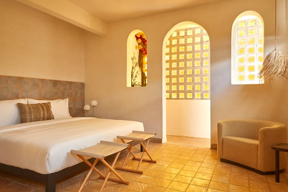 King bed, warm golden tiles and arched breeze-block openings in Romantic