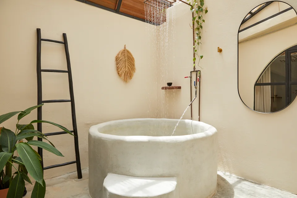 Circular soaking tub and rain shower in Visionary’s private bathing space