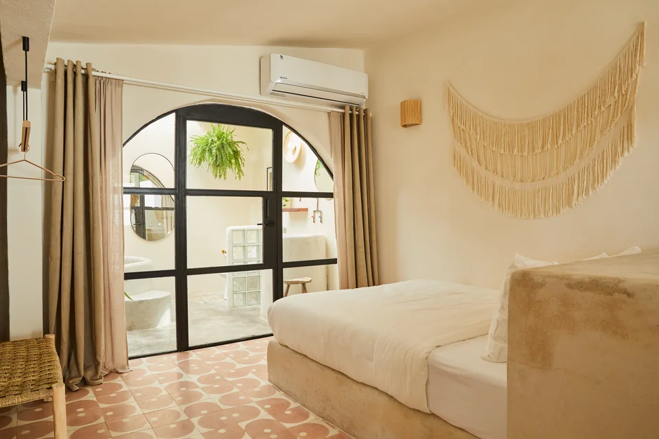 Queen bed, arched glass doors and a woven wall hanging in Visionary