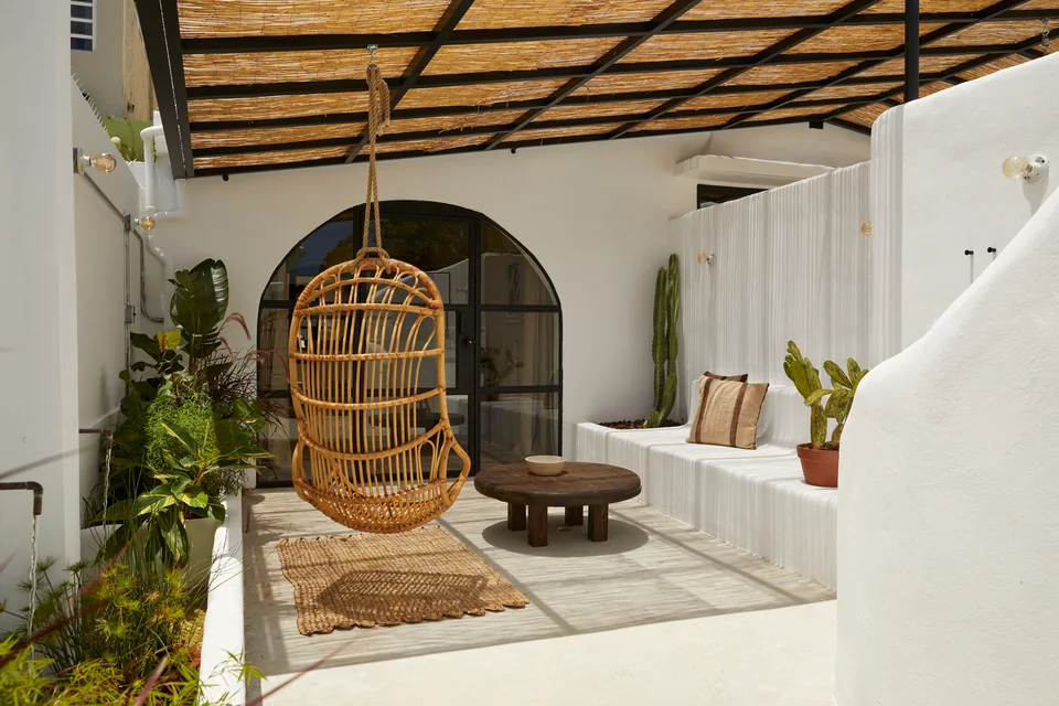 A hanging chair and built-in white seating on Visionary’s private terrace