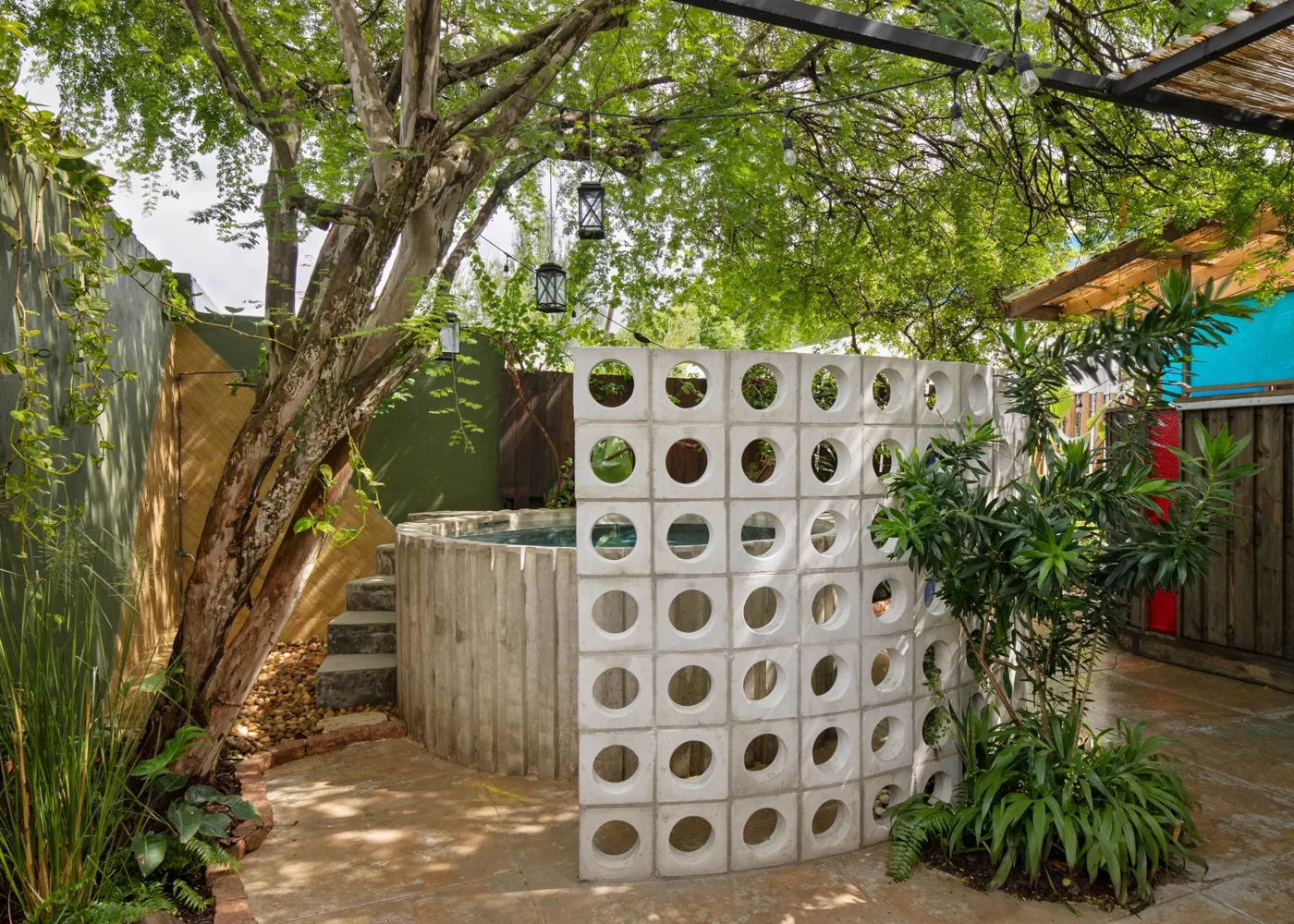 Concrete breeze-block screens and leafy planting in the Dreamcatcher courtyard.