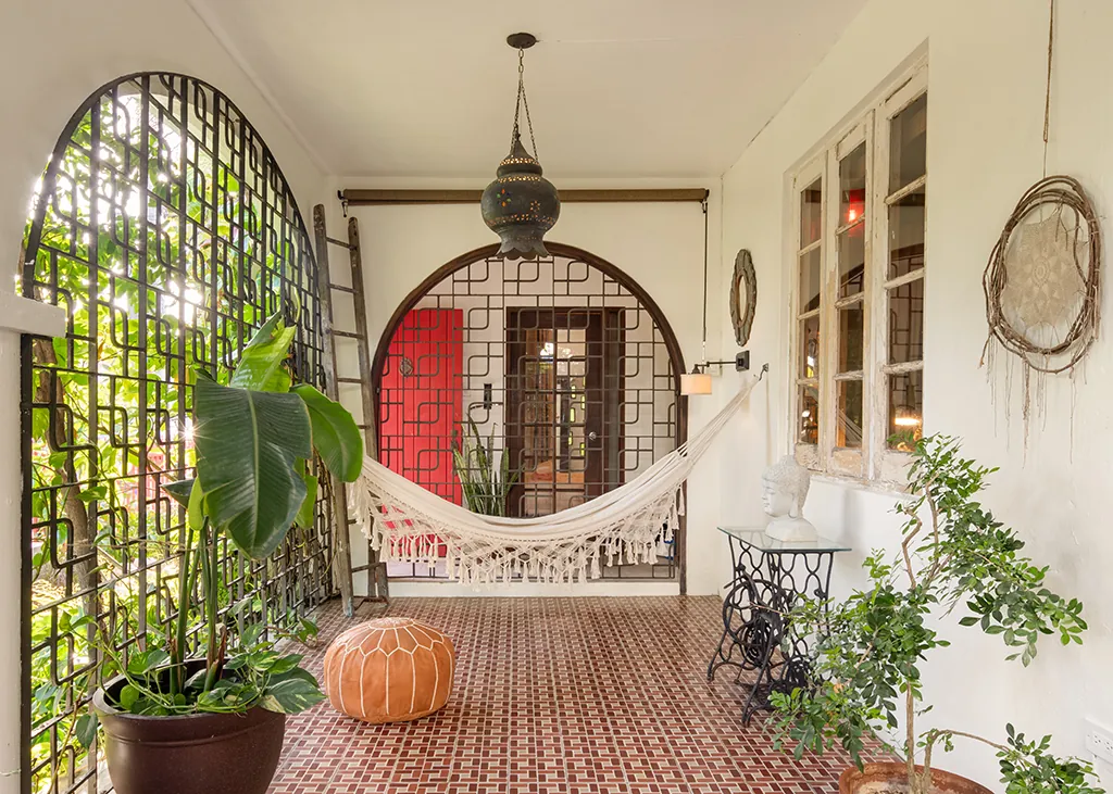 A hammock, hanging lantern and lush plants in an arched Dreamcatcher terrace.