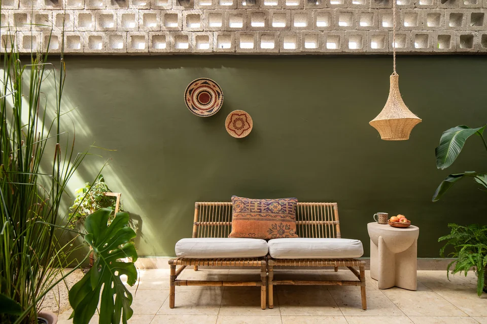 Green-walled private patio with seating and a hammock at UMI