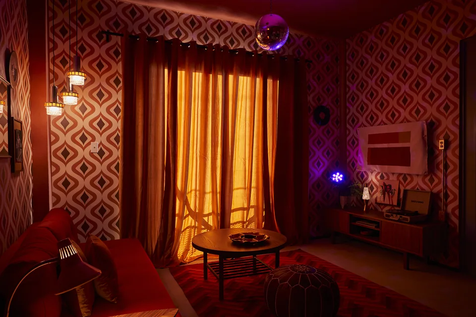 Diana’s patterned living room with a disco ball and warm red mood lighting
