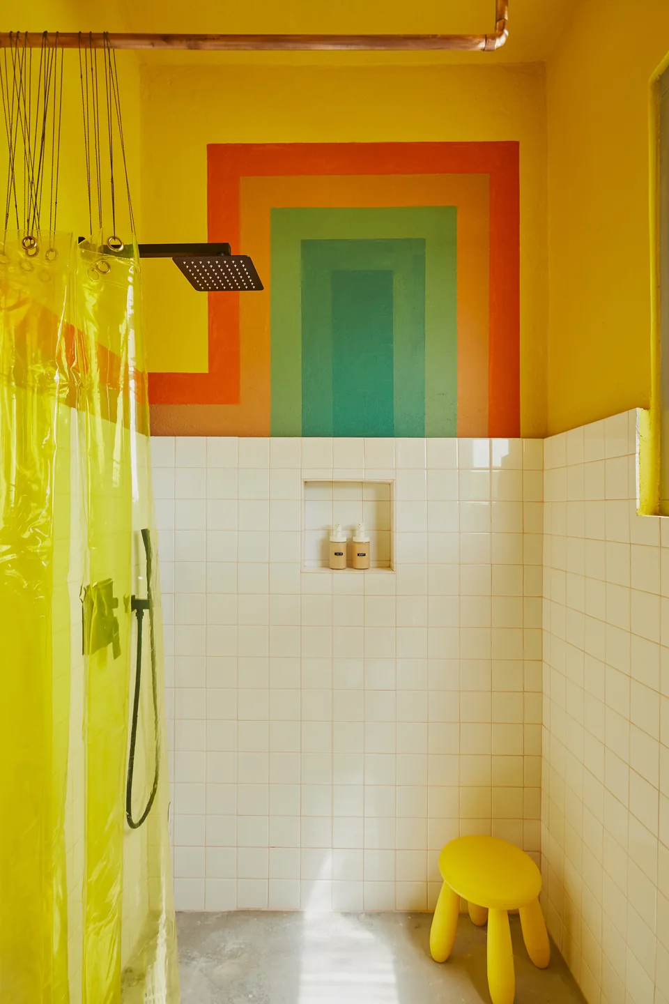 Yellow and orange geometric walls in Donna’s rain-shower bathroom