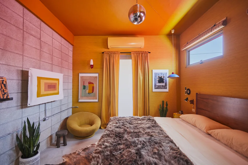 Mandarin walls, a king bed and a disco ball in Donna’s studio
