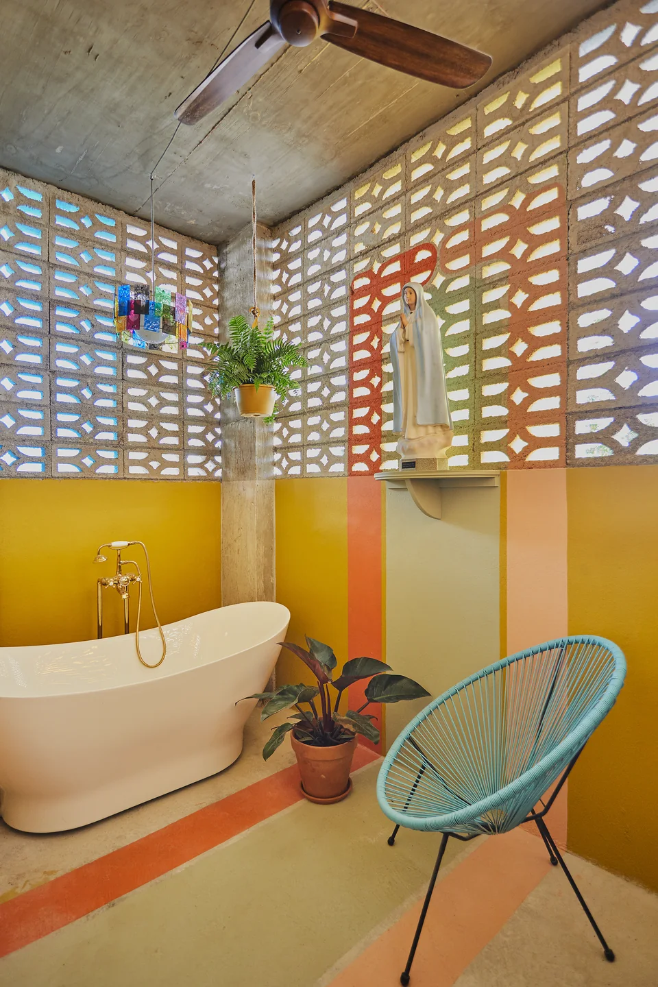 Outdoor soaking tub and turquoise chair on Gloria’s sunny terrace