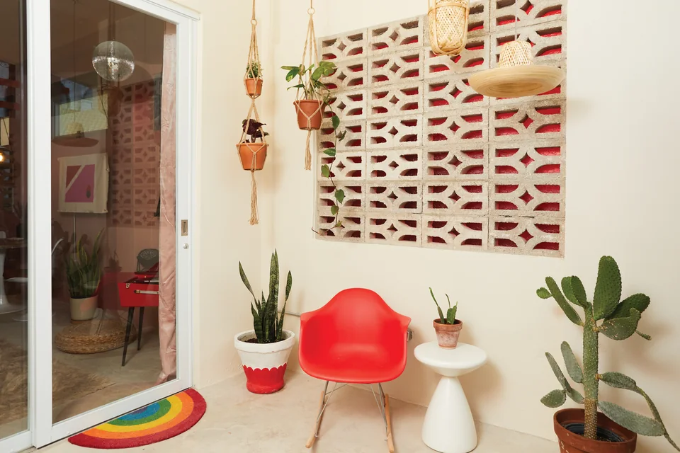 Breeze blocks, red seating and a hanging chair on Grace’s private terrace