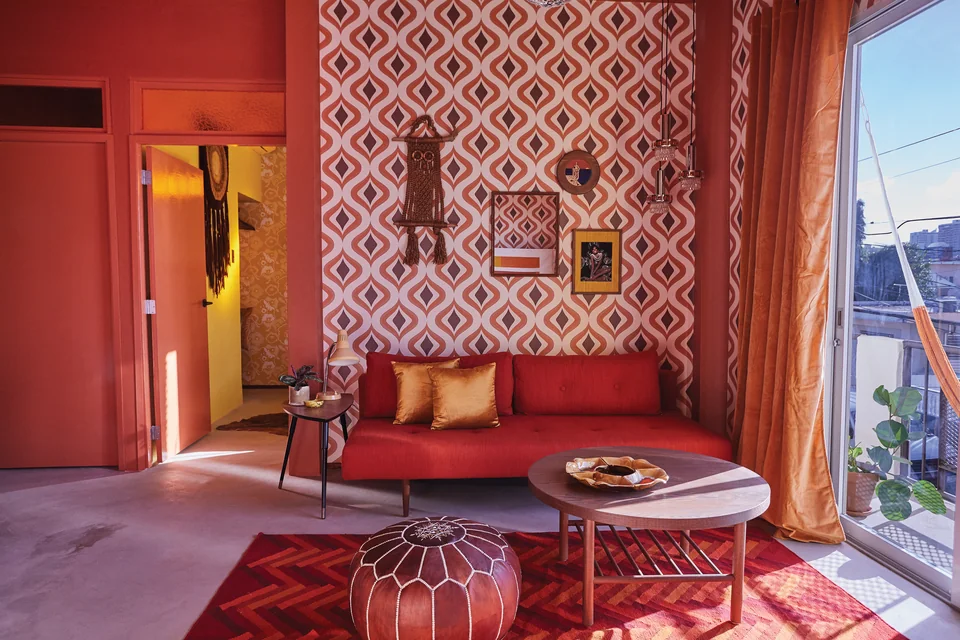 Patterned crimson wallpaper, a red sofa and vintage pieces in Diana’s living room