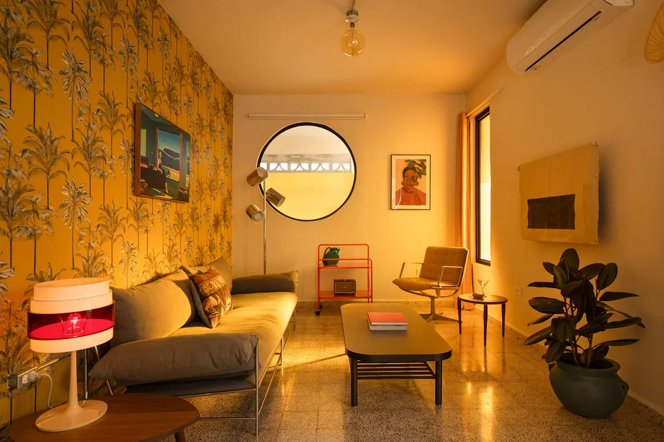Yellow floral wallpaper and warm seating in N’s living room