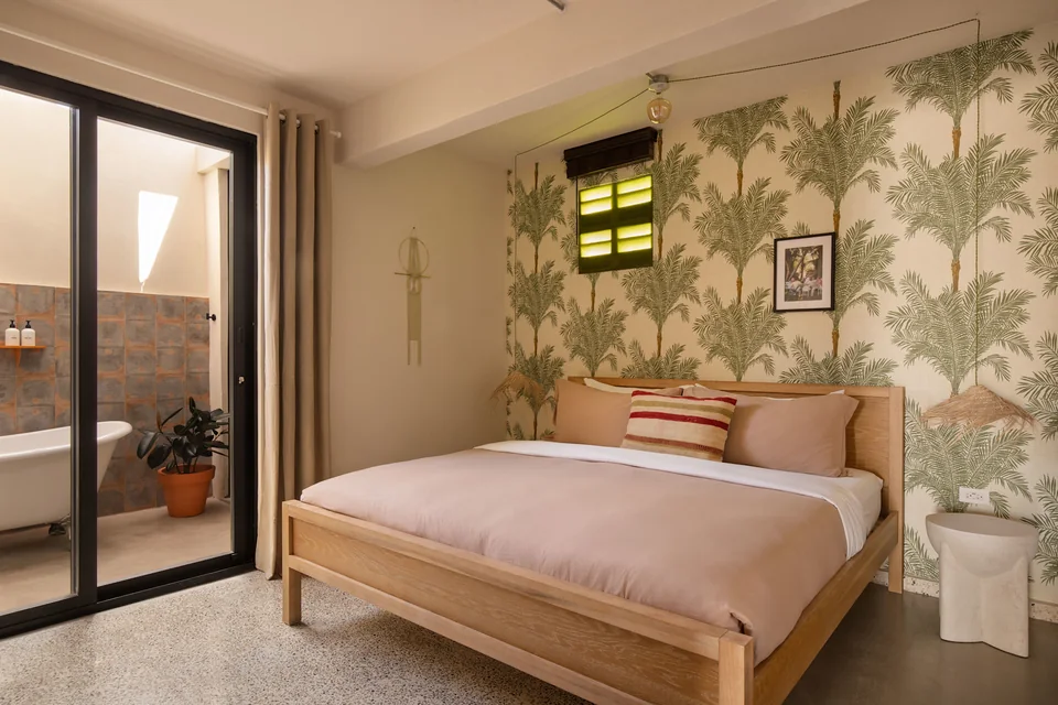 King bedroom with tropical wallpaper and a terrace door in O