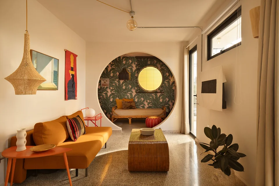 Ochre sofa and a circular opening in O’s living space