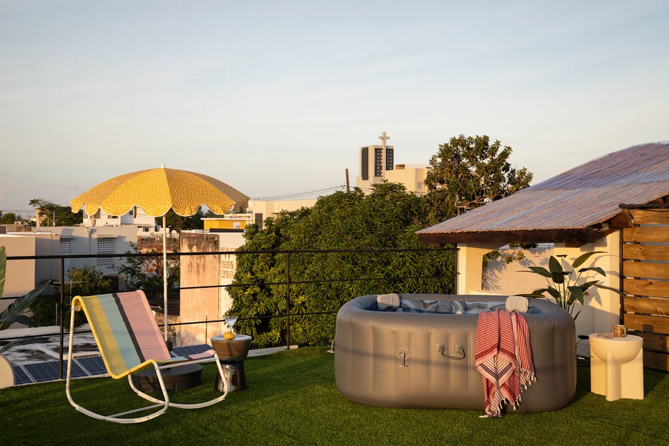O’s private roof deck with a hot tub, yellow parasol and loungers