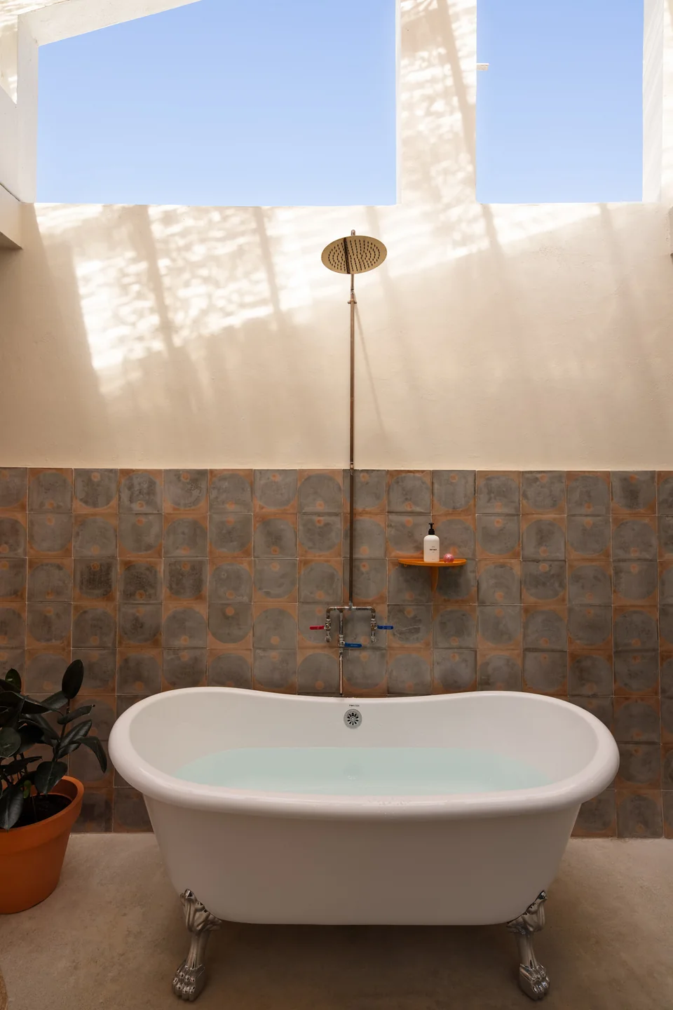 Outdoor soaking tub and shower beneath an open sky in O